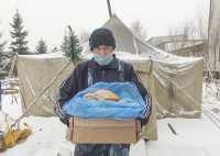 Андрей Гарус с хлебом от Абаканского пансионата ветеранов. А печь он уже протопил на совесть. 
