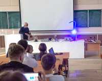 Преподаватель ХТИ Вениамин Стреж показывает учащимся, как работает синий лазер. В качестве «подопытного» выступает воздушный шарик, который мгновенно расплавляется и лопается при воздействии луча. 