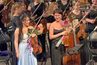Анастасия Субракова и Элиза Ханафина улыбаются аплодирующему залу после исполнения концерта Иоганнеса Брамса. 