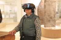 Особый интерес к VR-очкам проявили пенсионеры. Для них такие экскурсии — диковинка и даже аттракцион. Вот, к примеру, Вера держится за уголок стола, чтобы не терять связь с реальностью в виртуальном путешествии. 