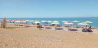 Чёрное море в Абхазии — чистое и тёплое. И на берегу всем хватает шезлонгов под зонтиками. 