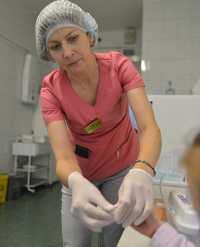 Фельдшер-лаборант Елена Шабуня в клинико-диагностической лаборатории проводит исследование крови на сахар. 
