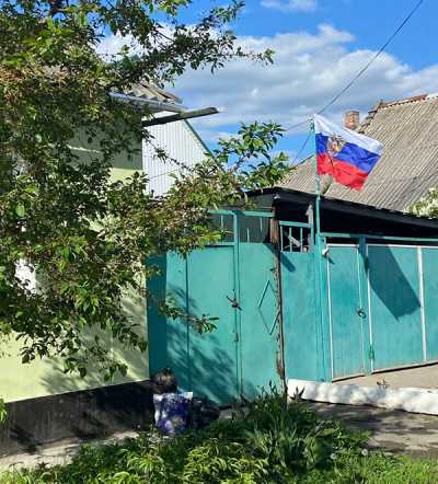 Российские флаги жители Луганска развешивают при входе в дома. 