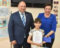 Парламентарии Валерий Старостин и Татьяна Янусик вручили награду победительнице во второй группе среди 5 — 9-х классов Анастасии Бяковой. 