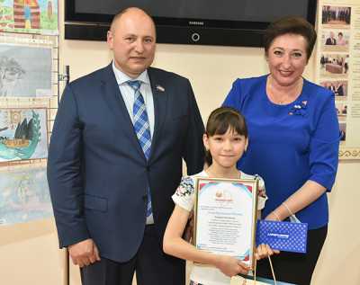 Парламентарии Валерий Старостин и Татьяна Янусик вручили награду победительнице во второй группе среди 5 — 9-х классов Анастасии Бяковой. 