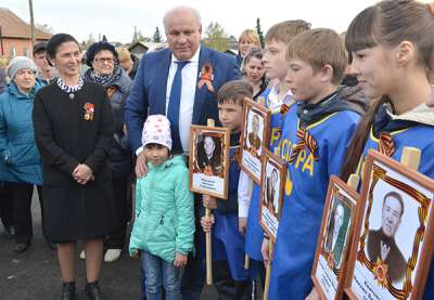Глава Хакасии Виктор Зимин с волонтёрами отряда «Опора» и сельчанами у мемориала в селе Подсинее.