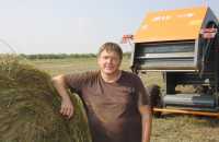 Сено с поля фермер Александр Внуков вывозит на самодельном прицепе с зигзагообразными бортами. Благодаря особой конструкции в него можно загрузить до 27 золотистых рулонов