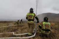 Пожарные Хакасии в дождь поливают траву в степи